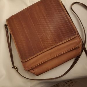 Brown, leather mid-size bag with adjustable and removable skinny shoulder strap.